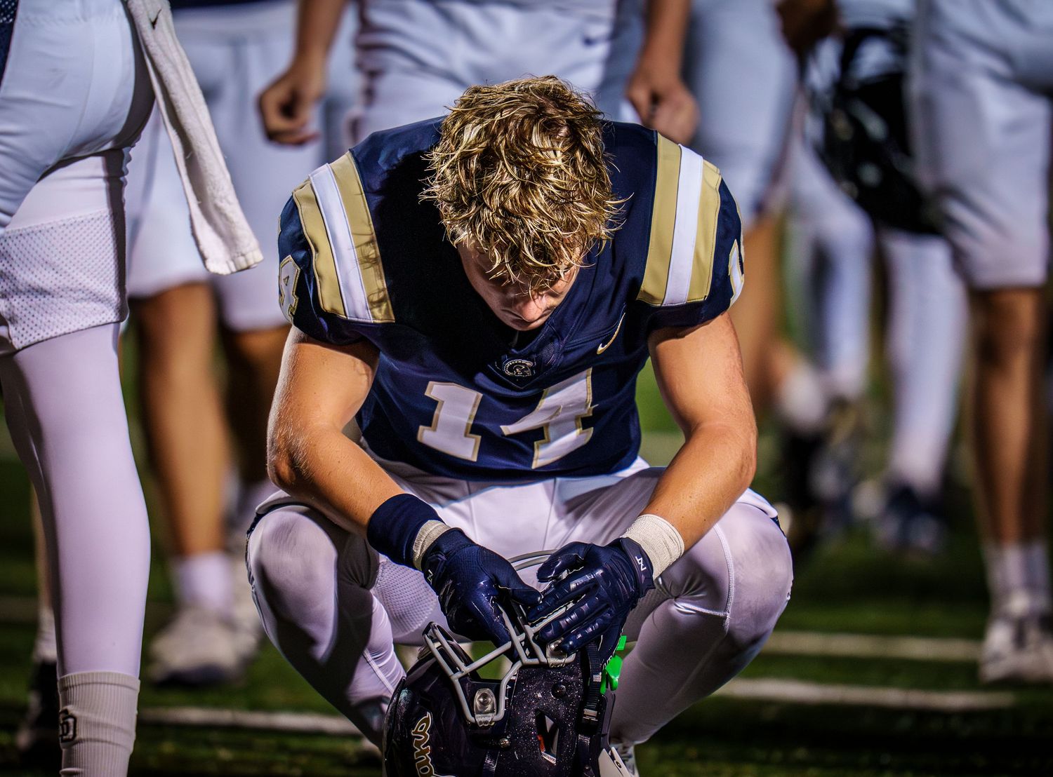 Football players kneeling on the field during a game break.