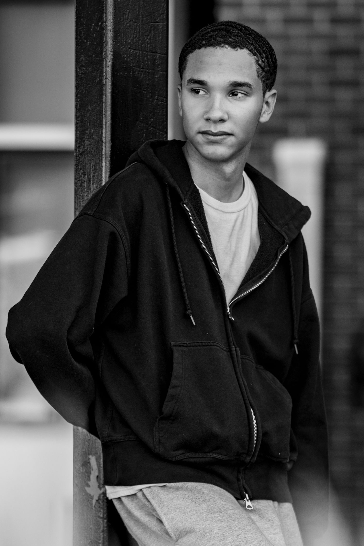 Portrait series against brick wall background in black and white.