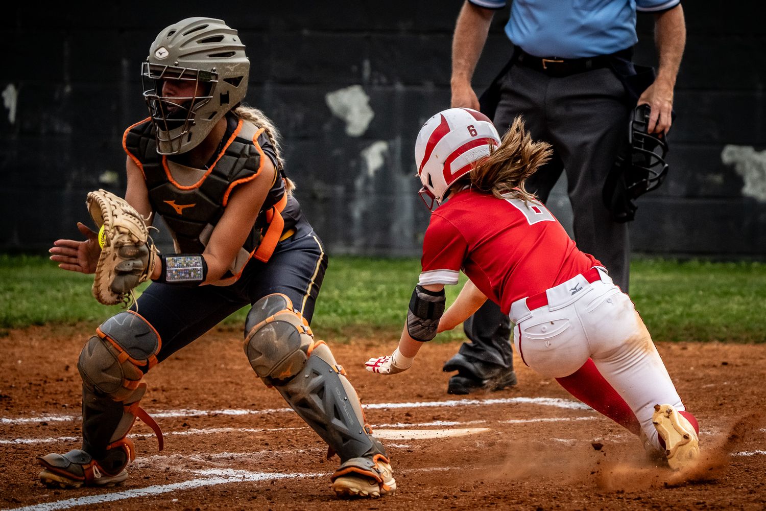 Close-up of a play at home plate between baserunner and catcher.