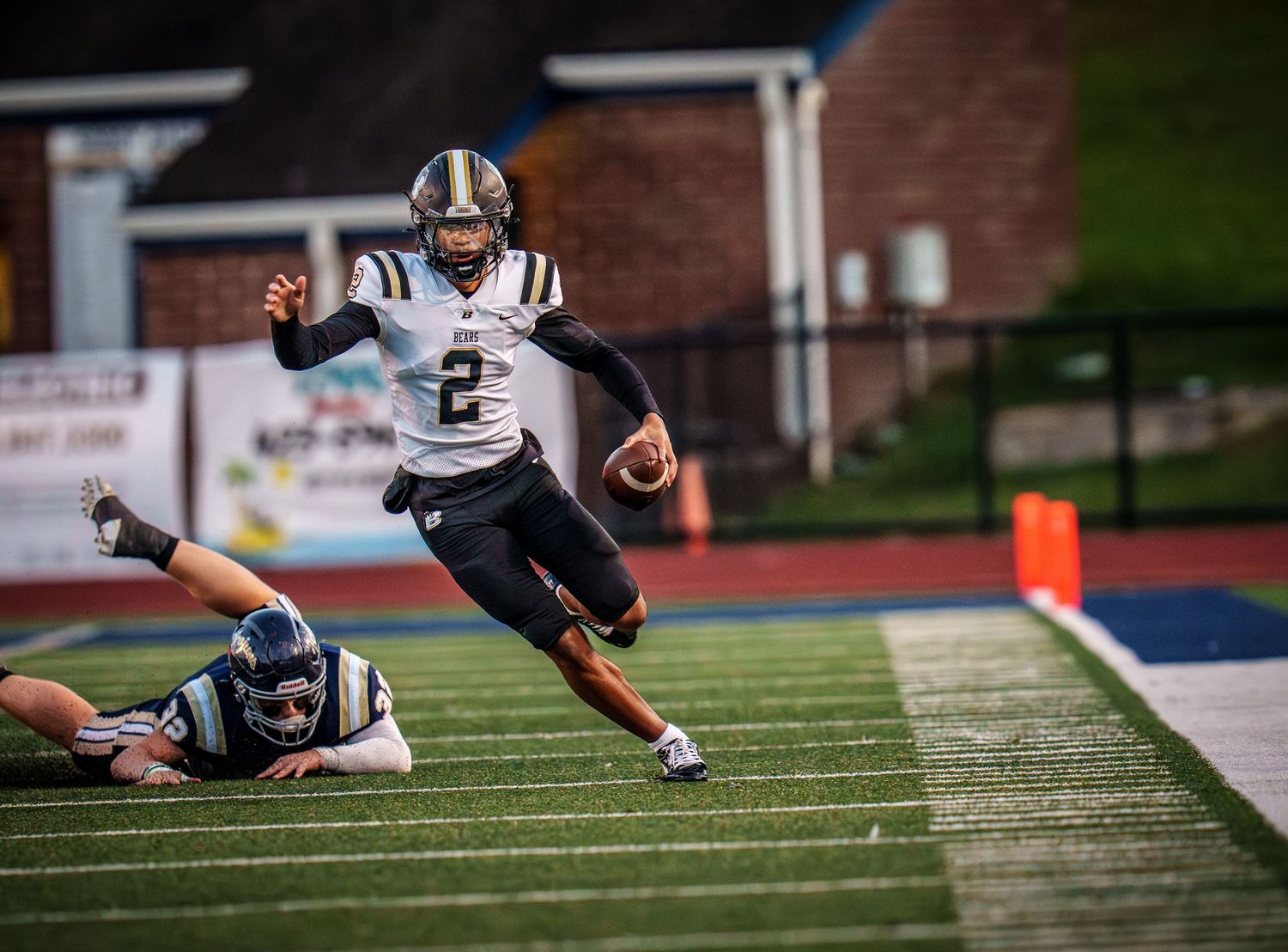 Football player diving to make a tackle during a game on the field.