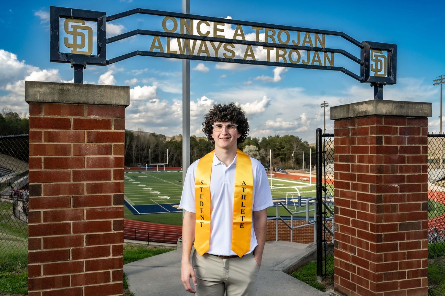 A brick entrance gate with 'Always A Gopher' signage welcomes visitors to an athletic field on a sunny day.