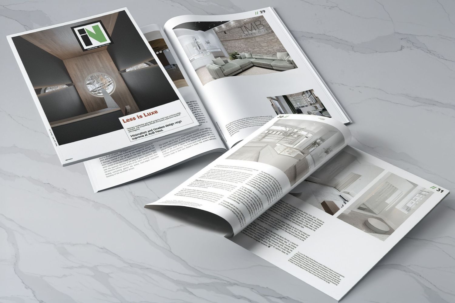 Open magazine spread with minimalist interior design layouts and photography on white marble surface.