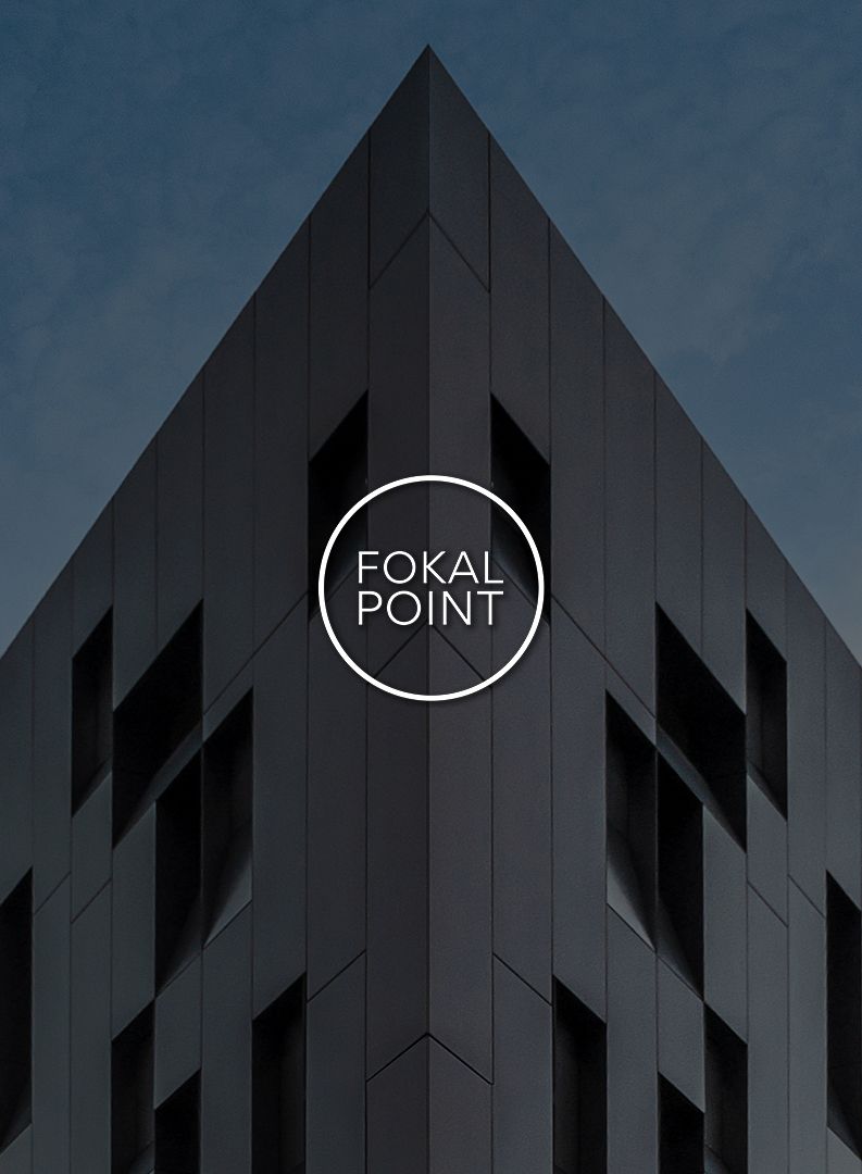 Dark architectural detail of modern building with angular geometric shapes against moody blue sky.