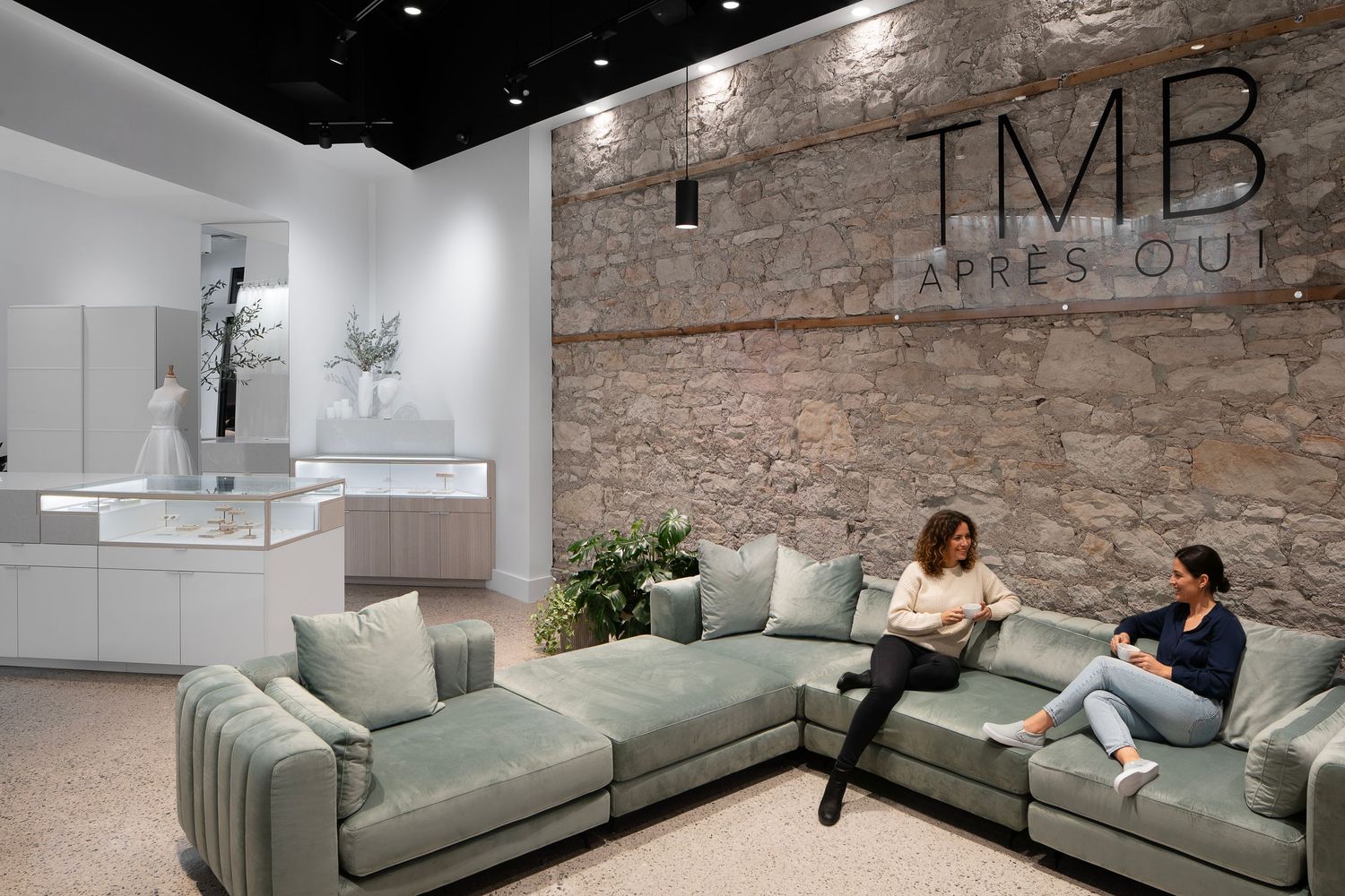 Modern living room interior with exposed brick walls, grey sectional sofa, and contemporary pendant lighting.