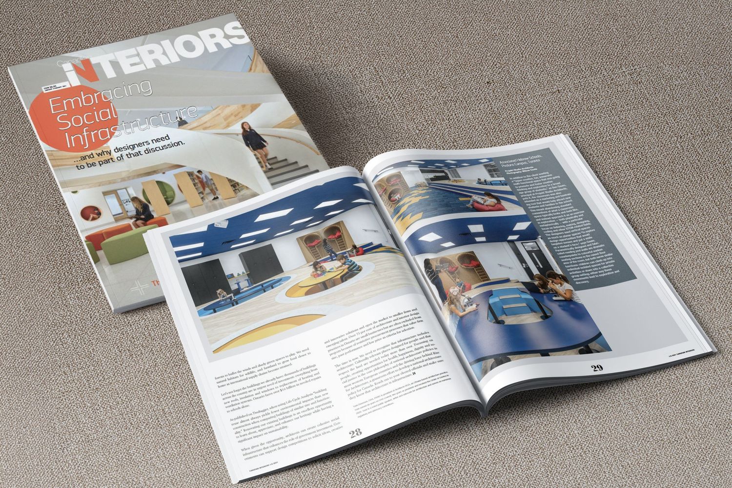 Open magazine and catalog showing interior design layouts with glossy pages on gray textured background.