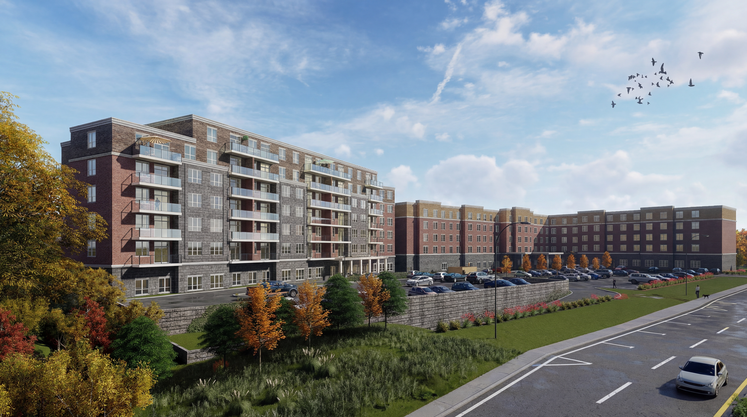 Panoramic view of modern apartment buildings with balconies against a blue sky with clouds.