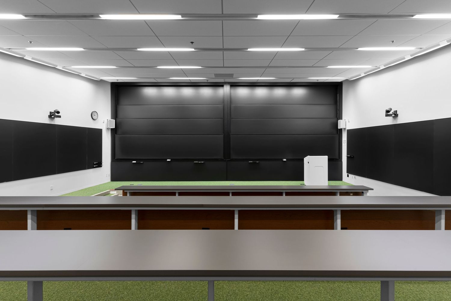 Modern office interior with fluorescent lighting and sleek minimalist design features white walls and ceiling panels.
