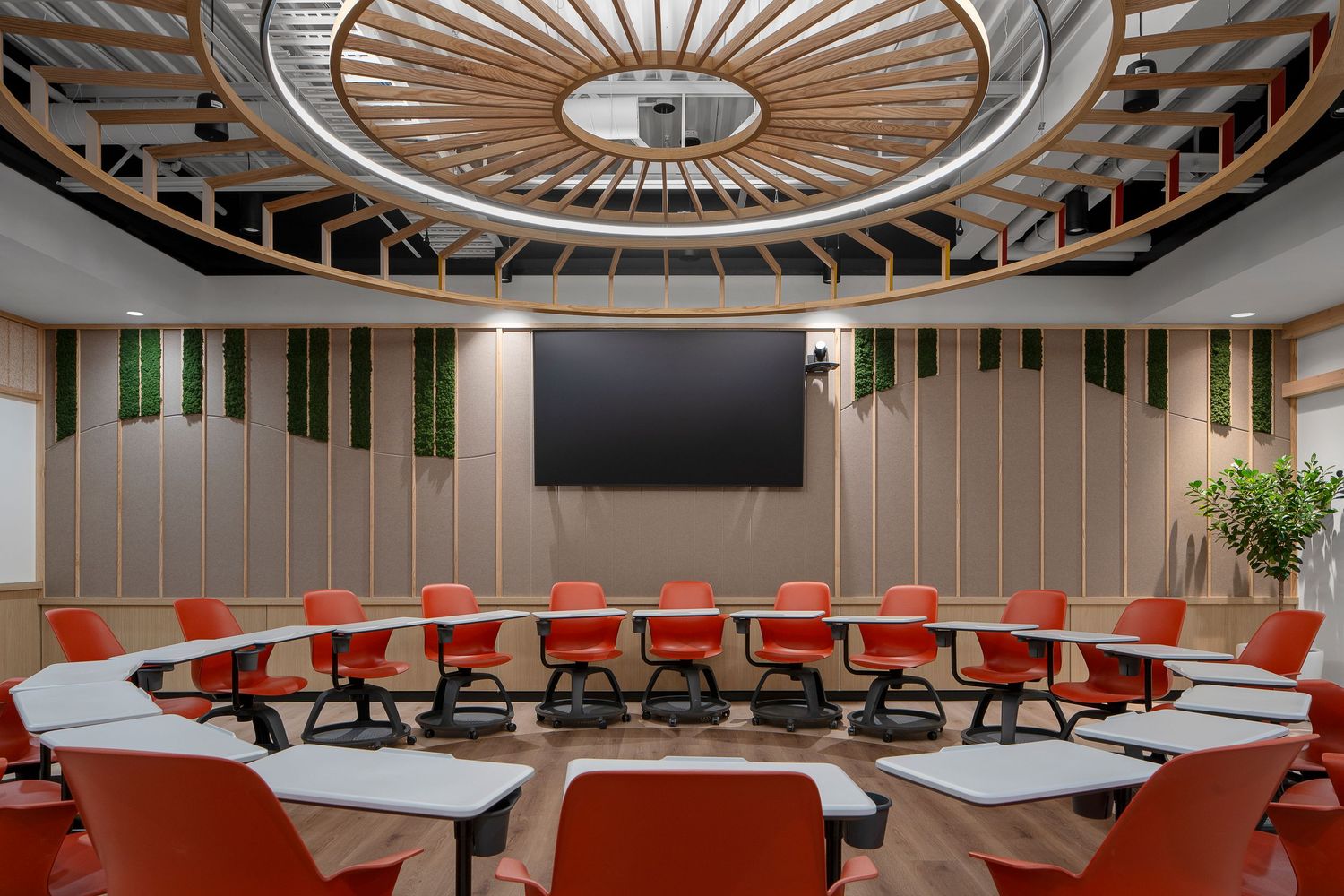Modern conference room features circular ceiling design with red chairs and white tables arranged in a curved layout.