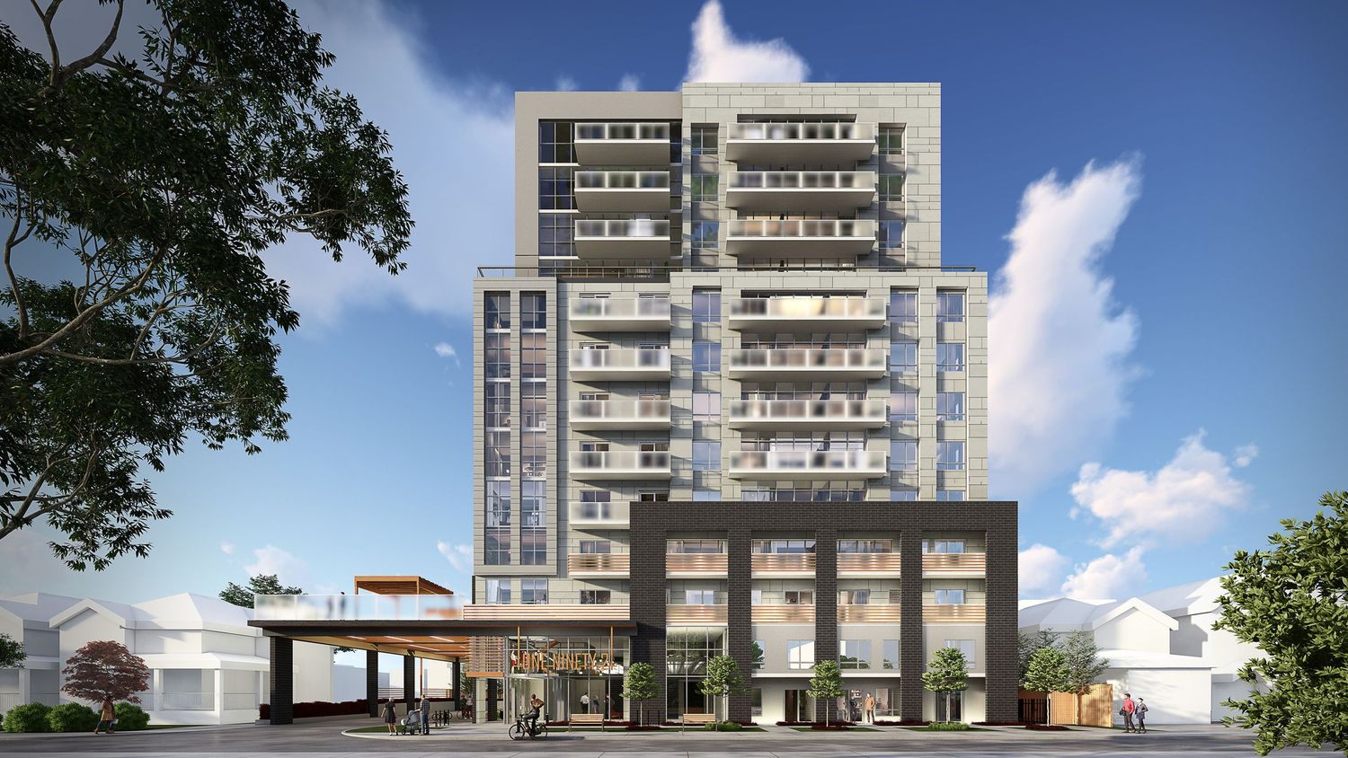 Modern residential apartment building complex with glass balconies and landscaping shown in a panoramic view against blue sky.