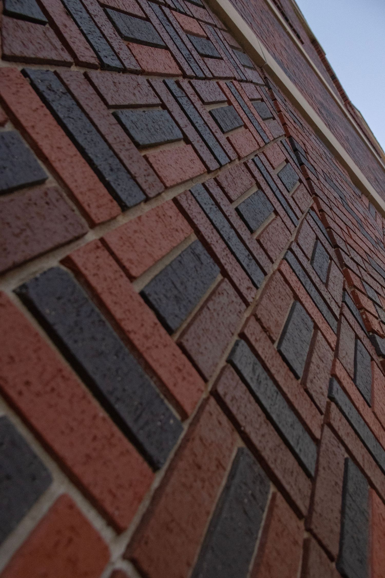 Professional architectural detail shot of a herringbone brick pattern walkway, by Haug & Bees Media.