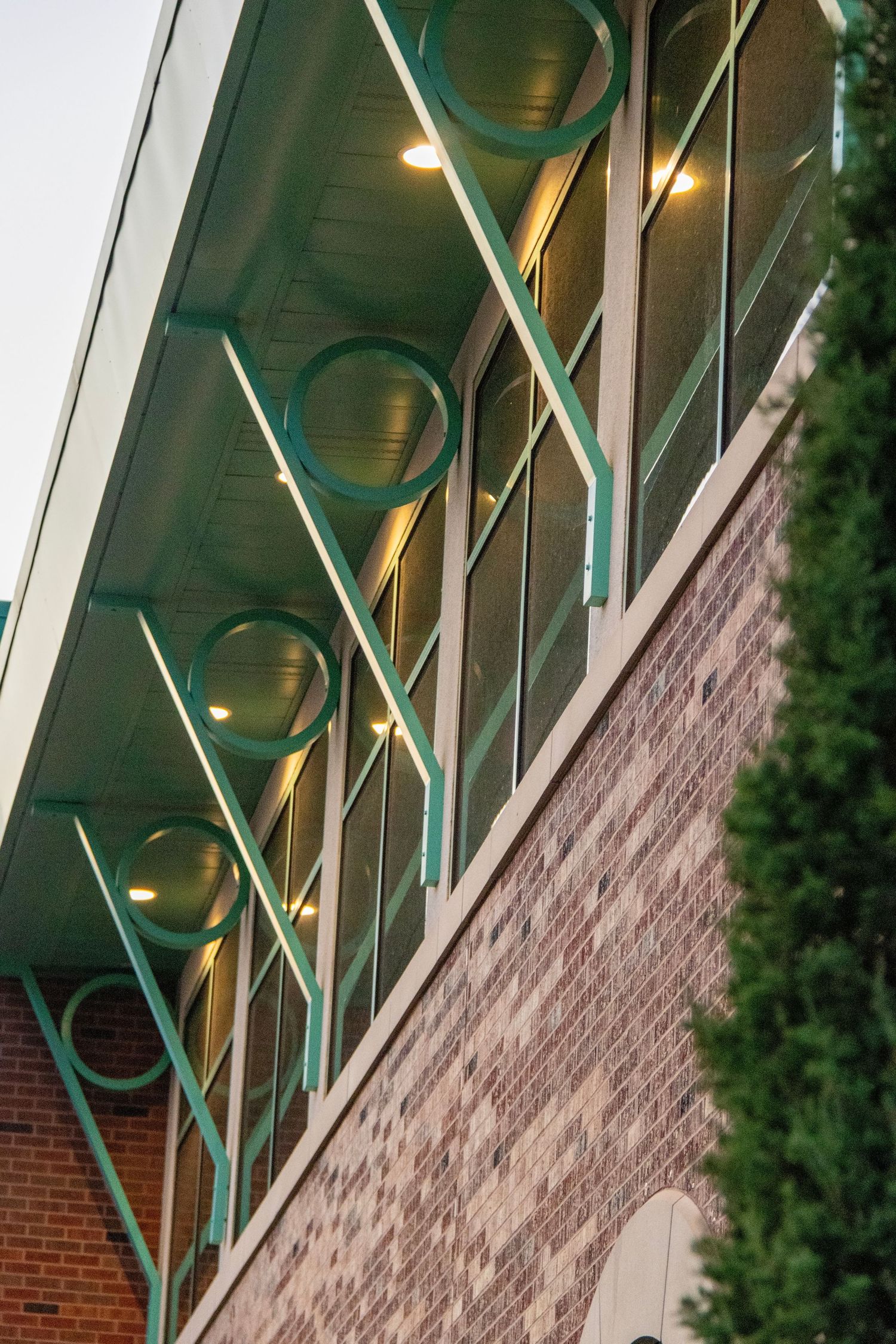 Modern architectural photography of a building's green steel overhang and brick facade, captured by Haug & Bees Media