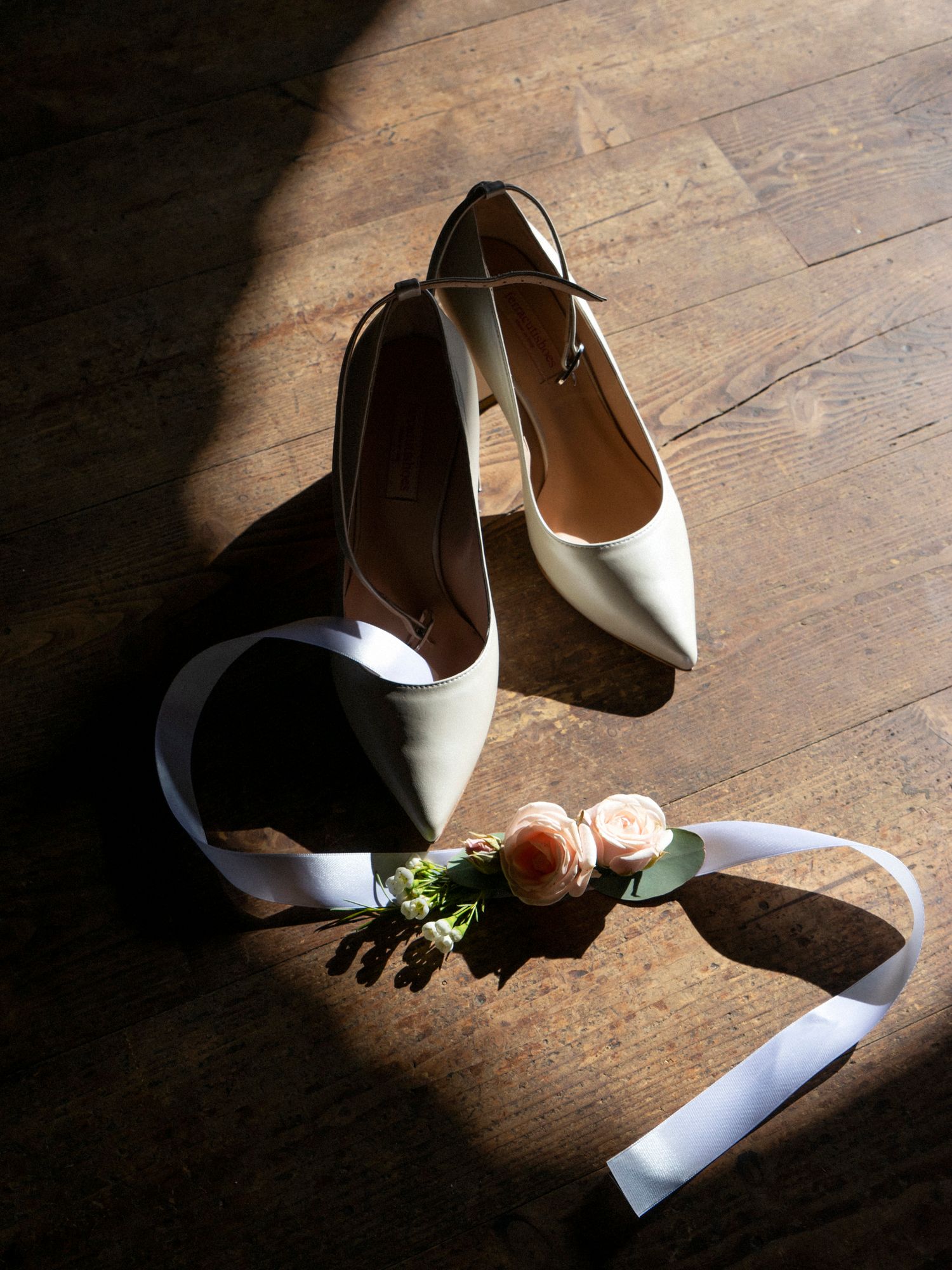 reportage autoriale di Stefania Bosso preparazione sposa dettaglio dele scarpe e fiori, luce naturale