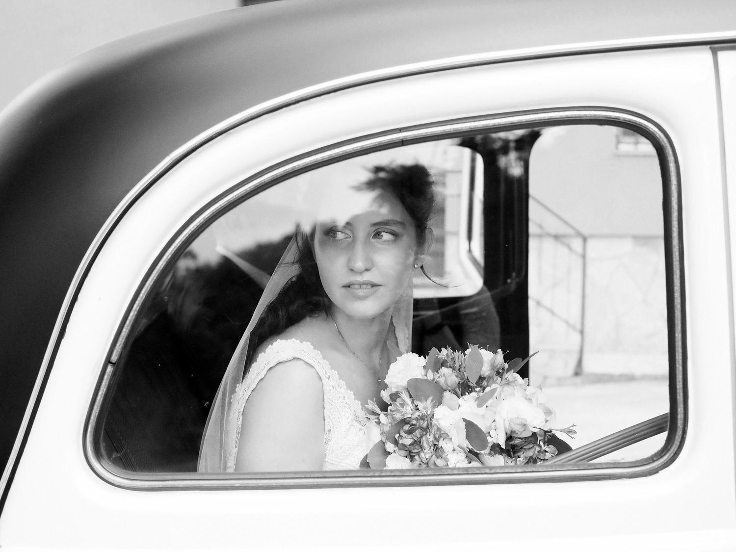 reportage naturale in bianco e nero, sposa in auto d'epoca