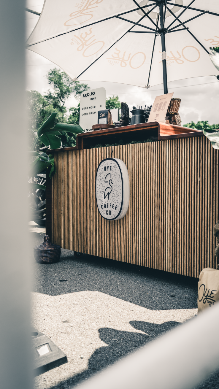 Wooden slatted barrier wall with umbrella shade in an outdoor setting.