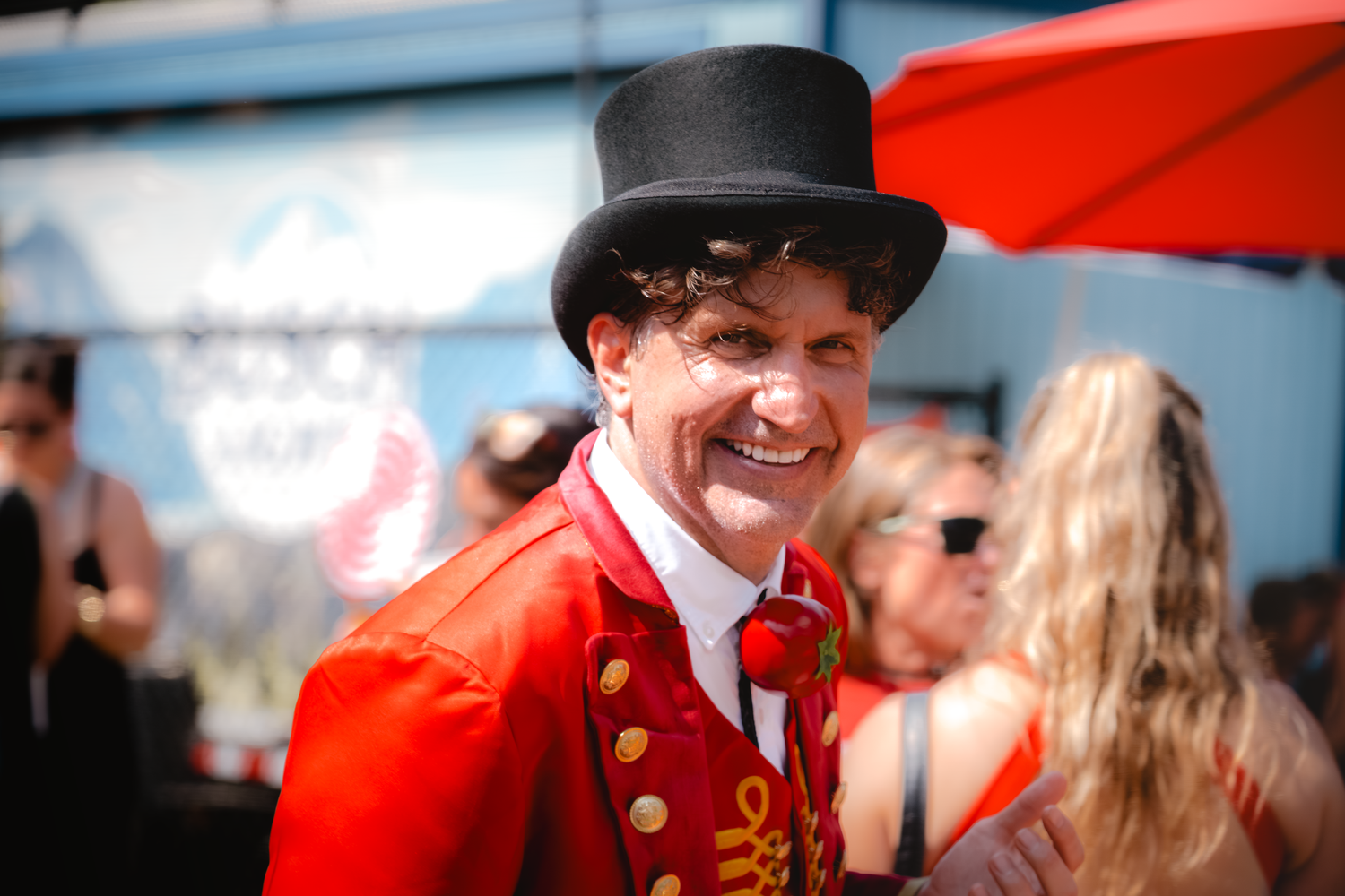 Group in red vintage costumes at outdoor festival gathering.