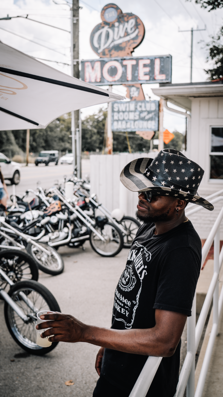 Motorcycles parked outside a venue with motel signage visible in background.