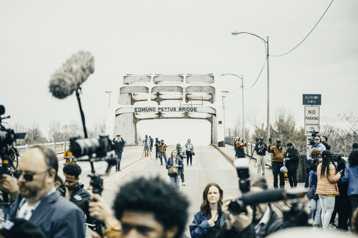 Large crowd gathering on historic Edmund Pettus Bridge during commemorative event.