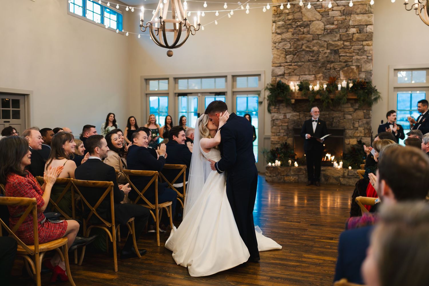 Bride and groom share their first kiss at the altar during an indoor wedding ceremony.
