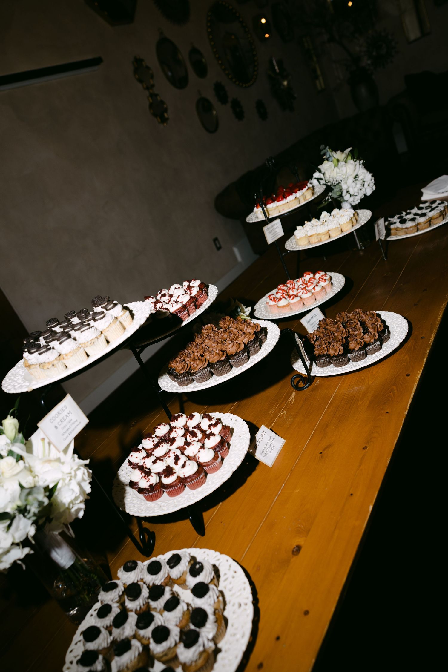 Elegant wedding dessert table displaying assorted treats including cupcakes, brownies, and pastries on tiered stands.