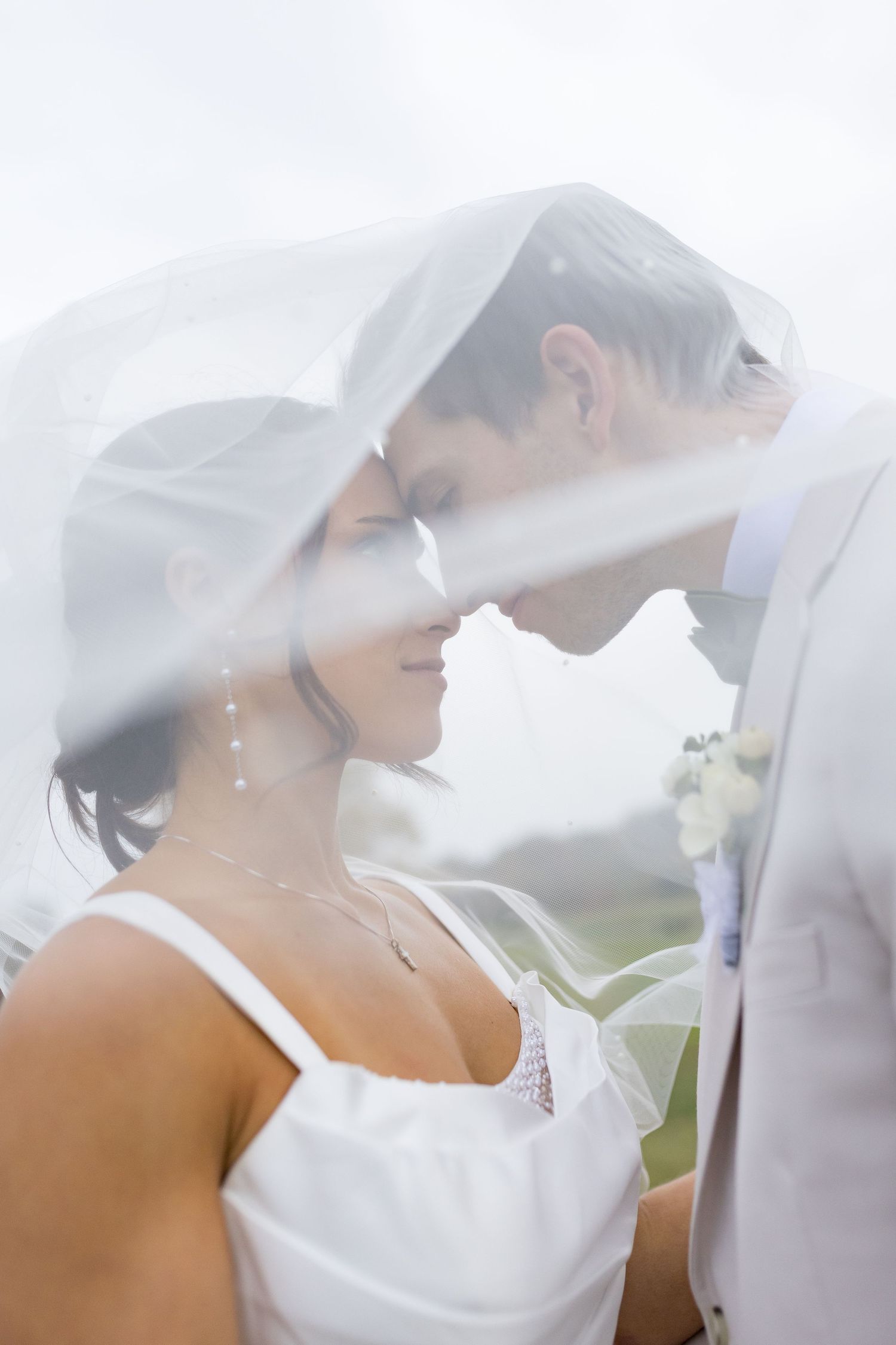 Bride and groom forehead to forehead under the bride's veil