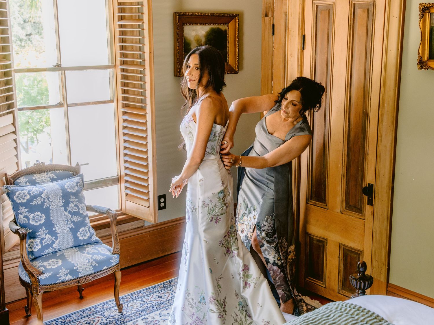 Getting ready moments in a warm-lit room with elegant window light and vintage decor.