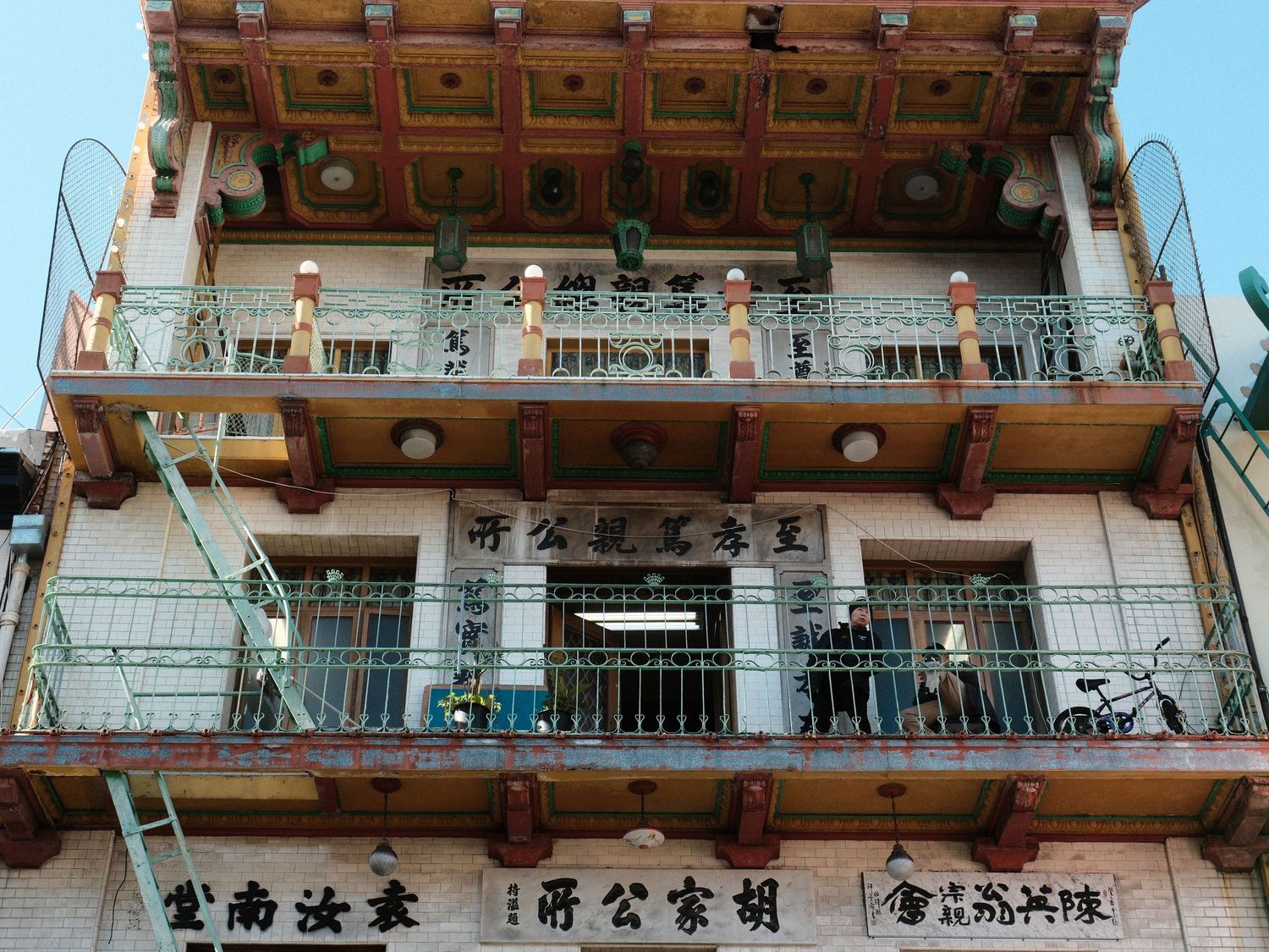 Traditional Chinese architecture with ornate balconies and decorative text on building facade.