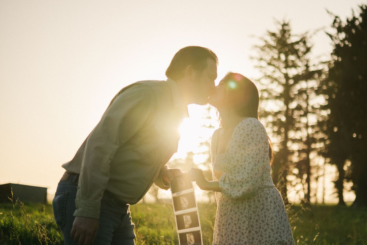 Romantic silhouettes against golden sunset light in a forest setting.