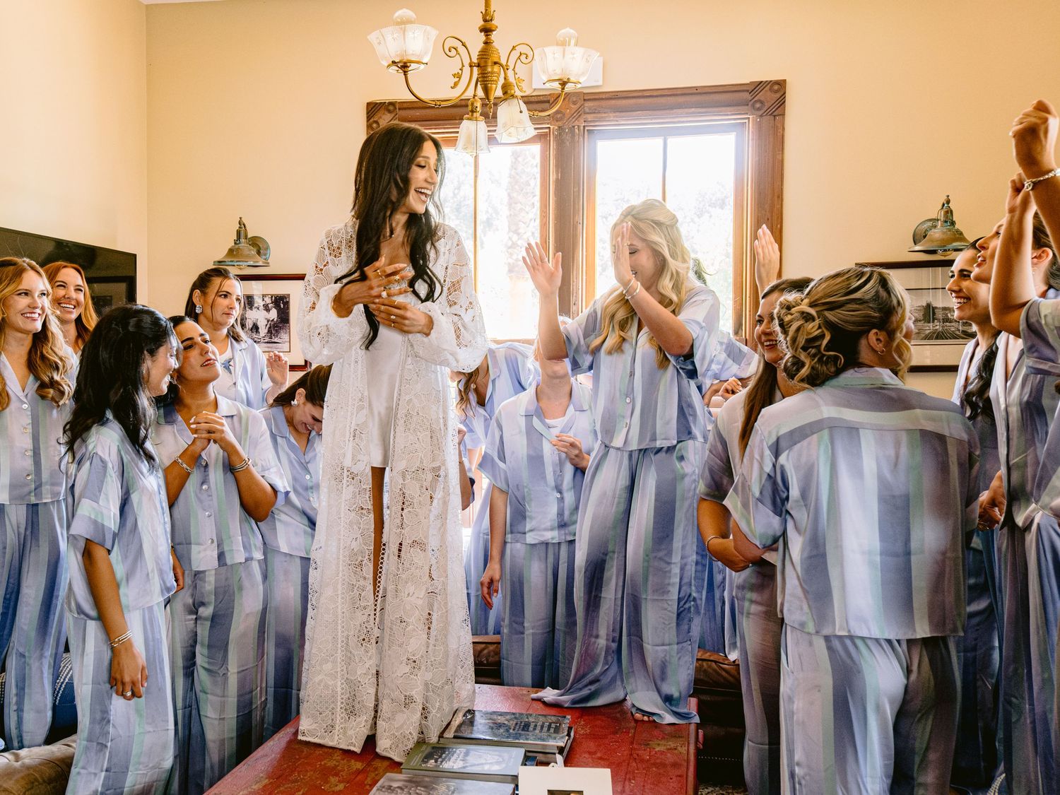 Wedding party members in light blue dresses gather in an elegant indoor venue.