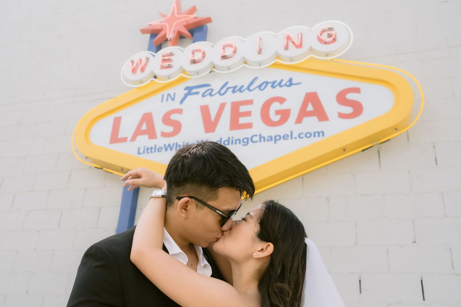 Wedding chapel signs in Las Vegas with iconic neon lighting against a blue sky.