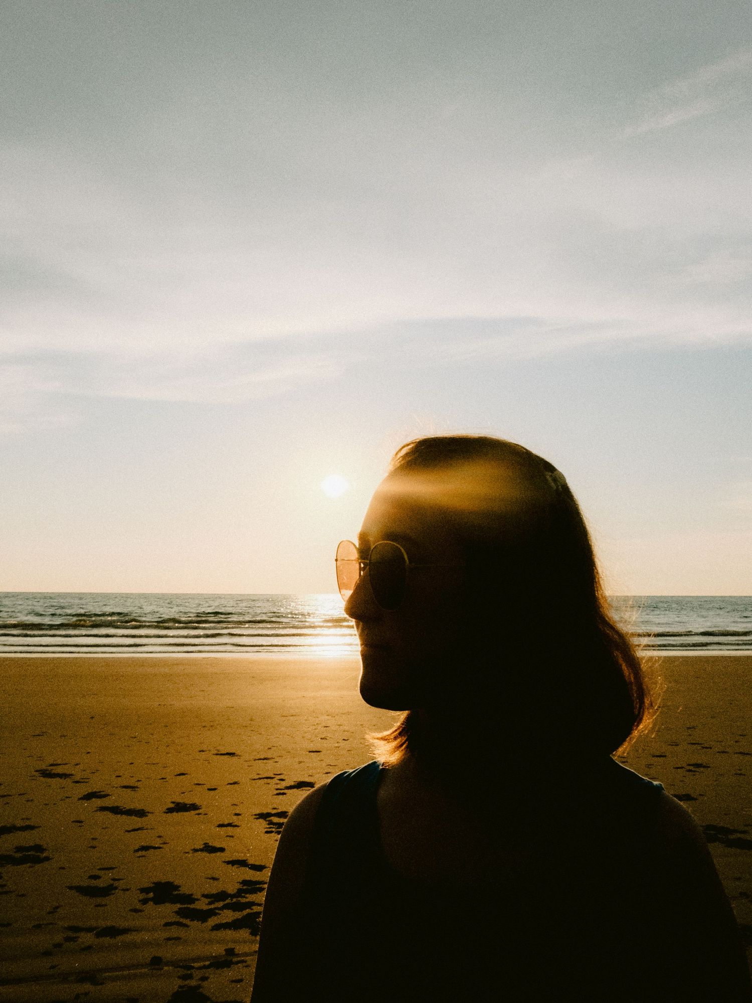 Silhouettes against a sunset beach horizon creating dramatic shadows.