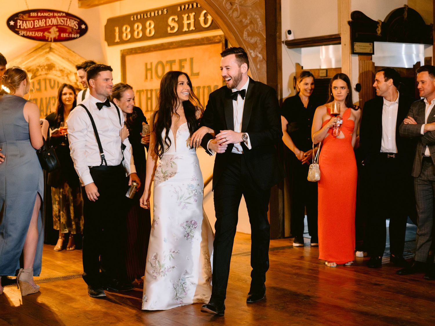 Wedding reception guests dancing and mingling under warm lighting at a rustic venue.