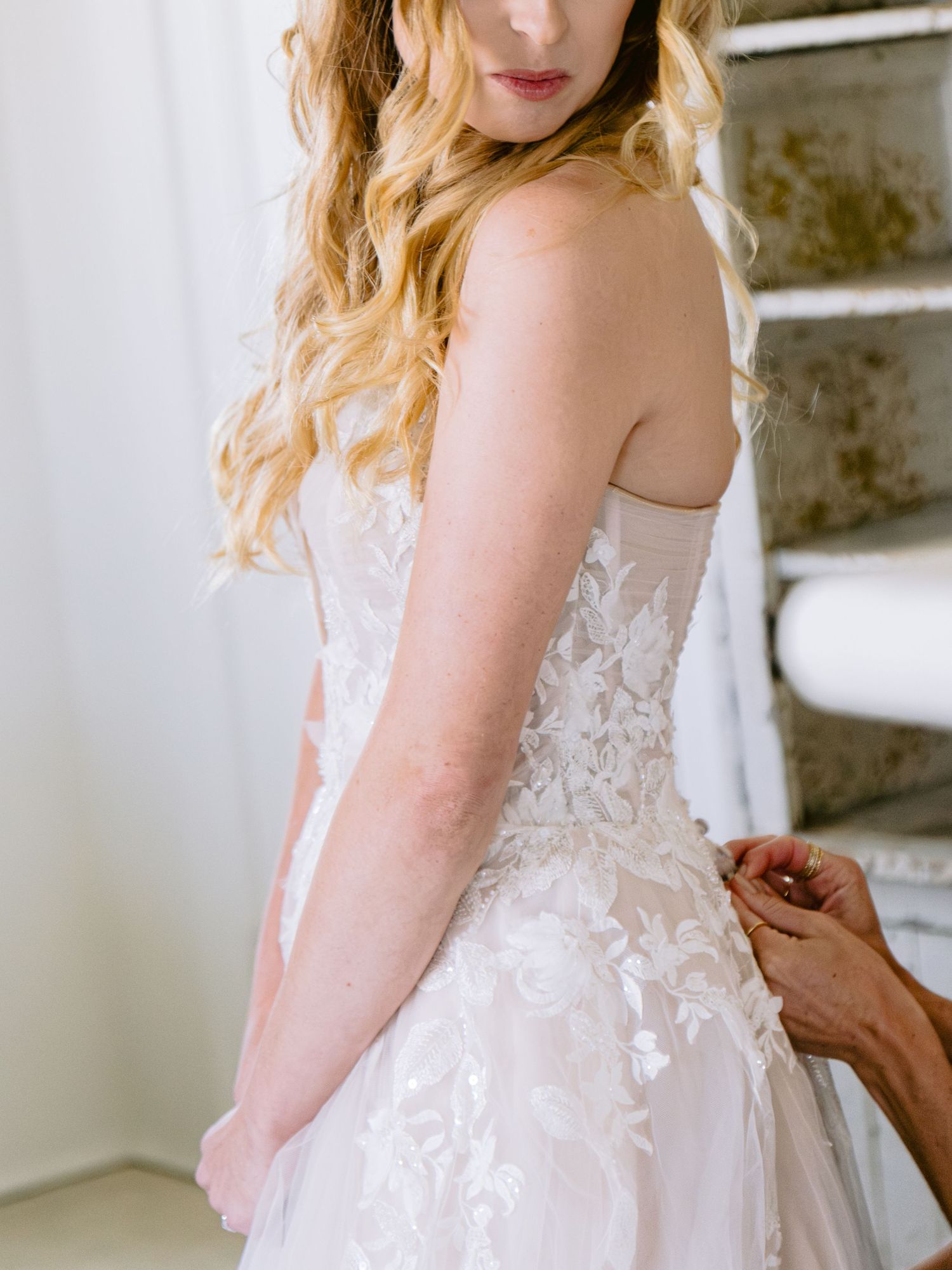 Ethereal white wedding dress with intricate lace details and flowing fabric.