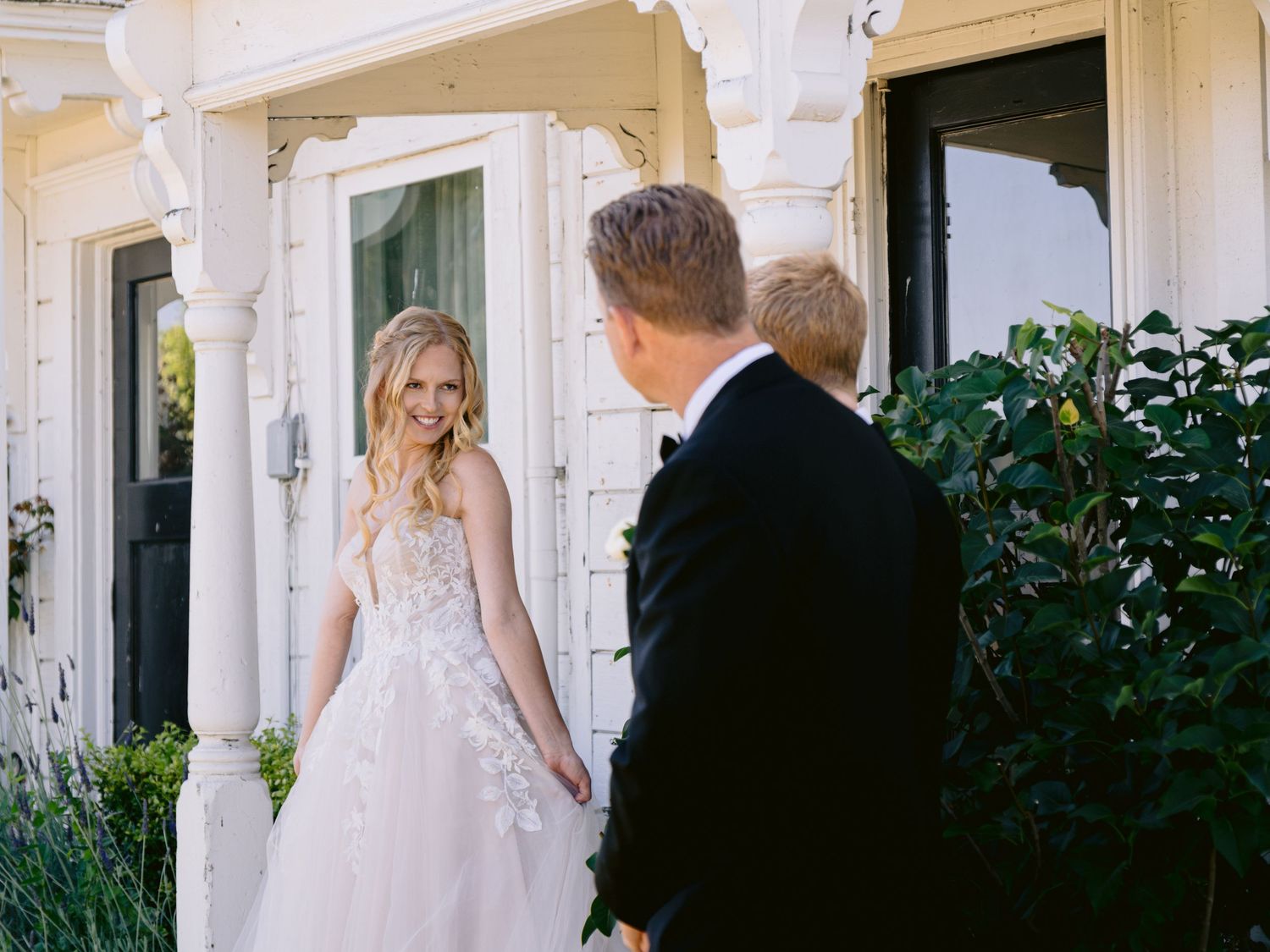 Elegant white wedding venue exterior with classic architectural details and greenery.