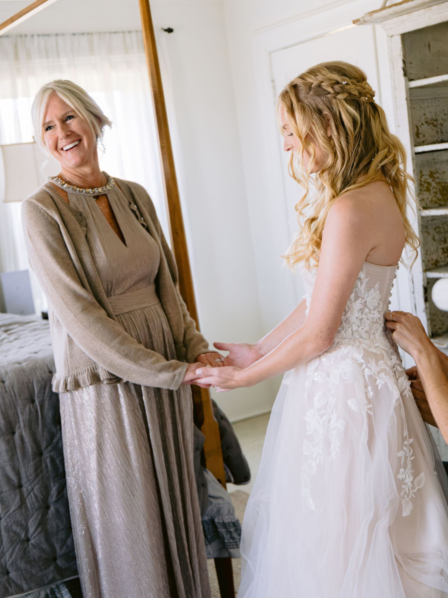 Getting ready moments show final wedding dress adjustments with warm neutral tones.