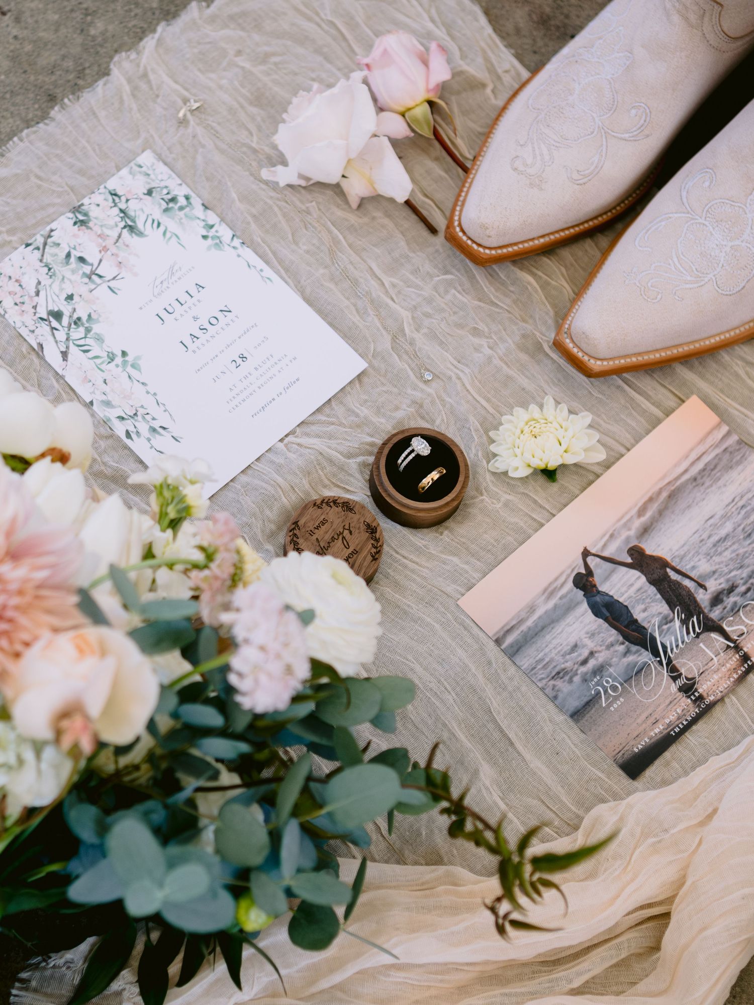 Wedding flat lay with invitation suite, flowers, and bridal accessories.