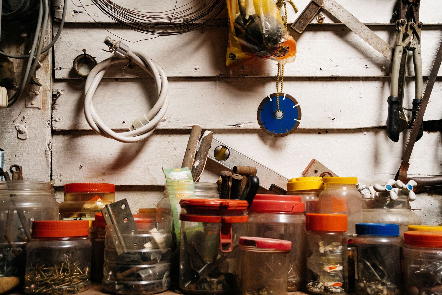 Collection of colorful cooking pots and kitchen equipment arranged on white shelving.