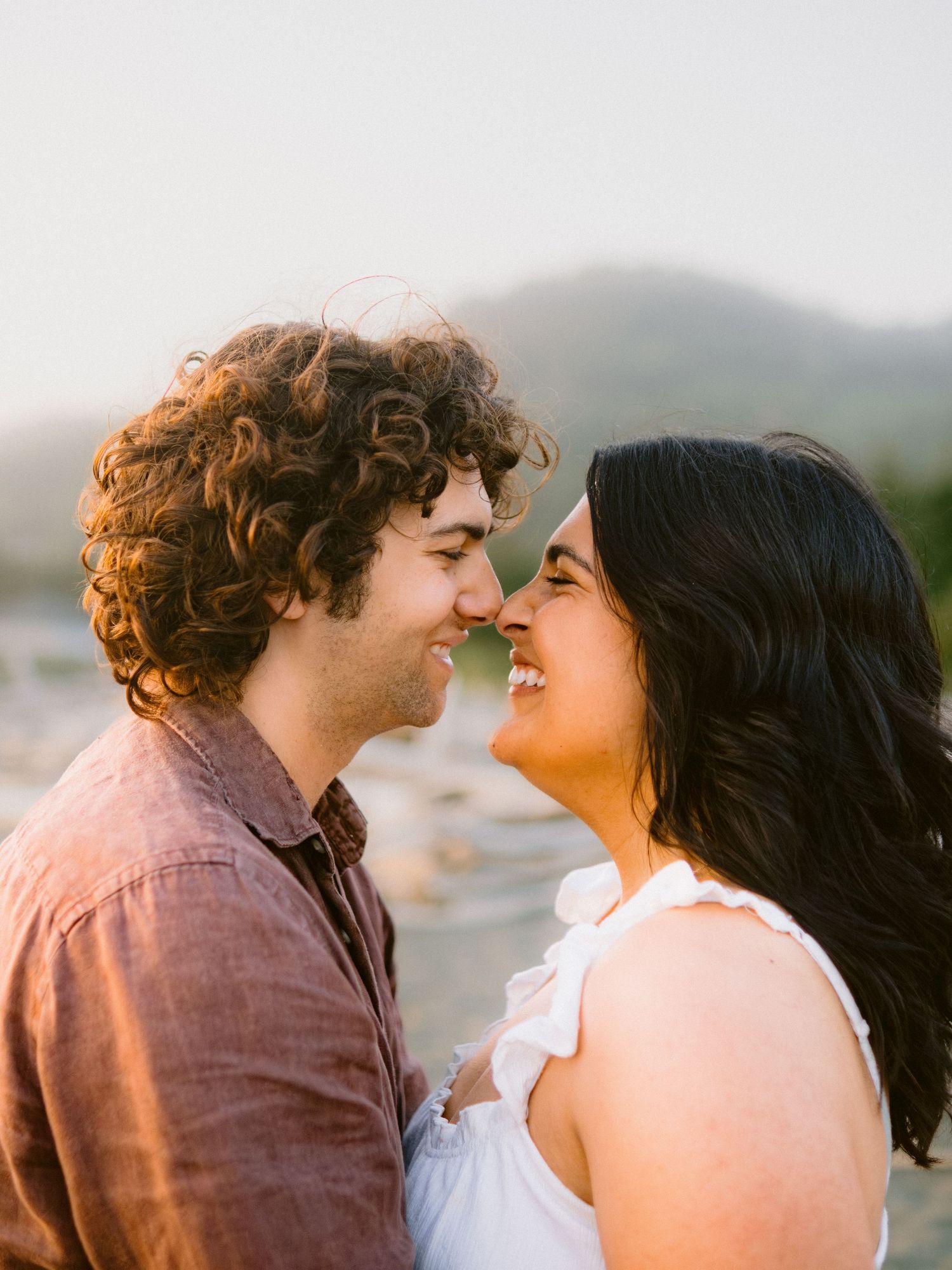 A romantic couple sharing tender moments together in warm sunlight.