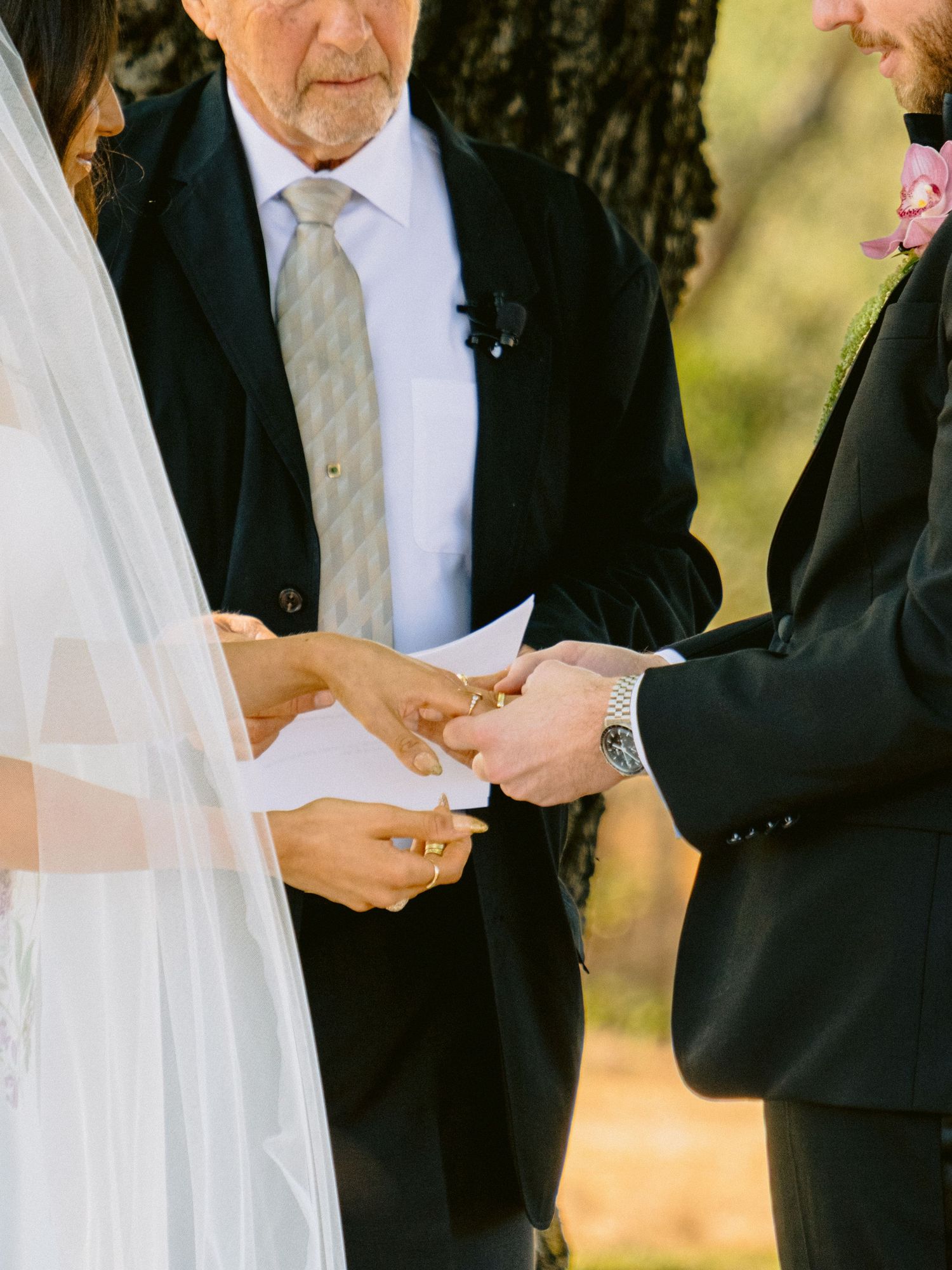 Wedding ceremony moment with exchange of vows outdoors.