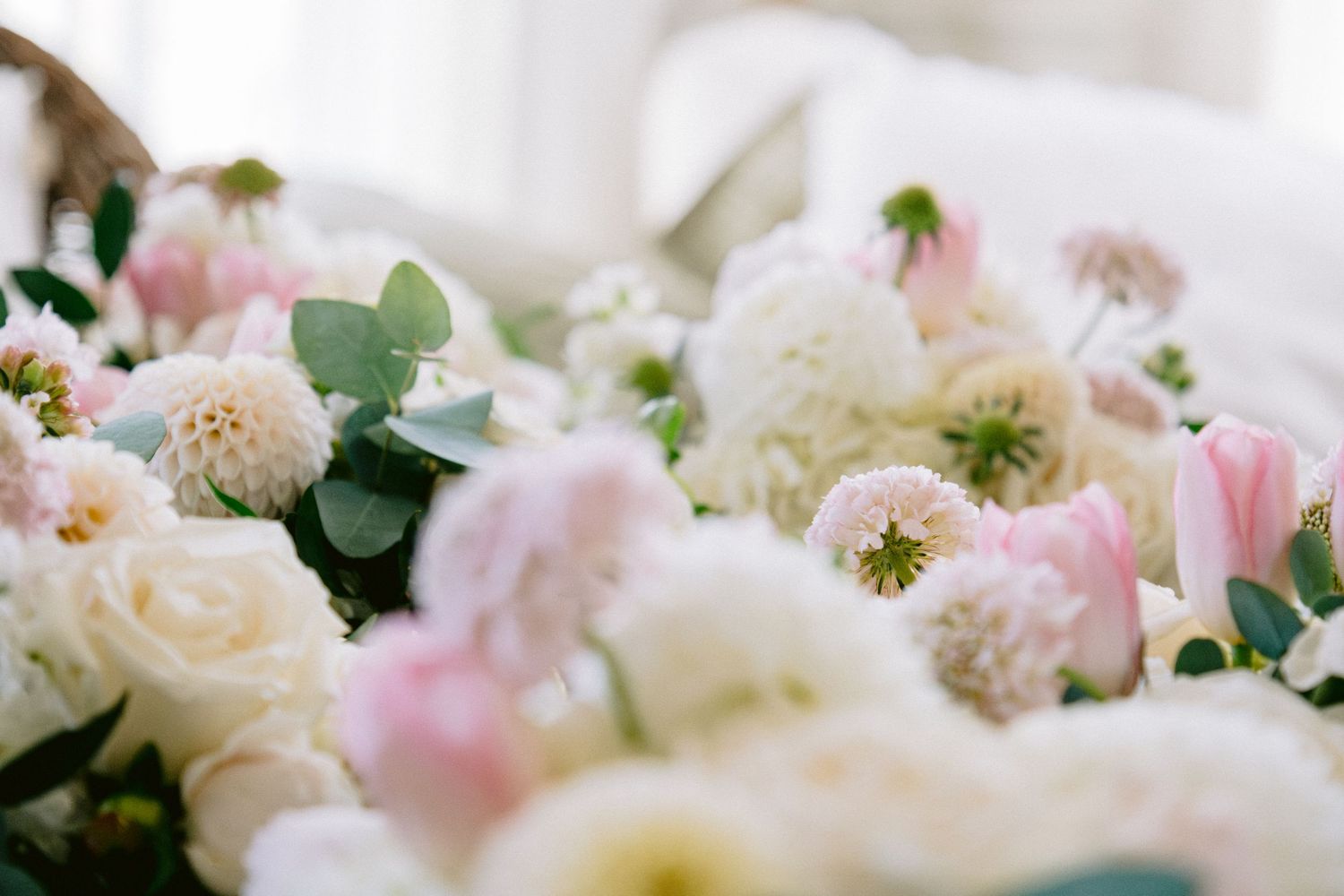 Soft pink and white floral arrangements with roses and delicate blooms.