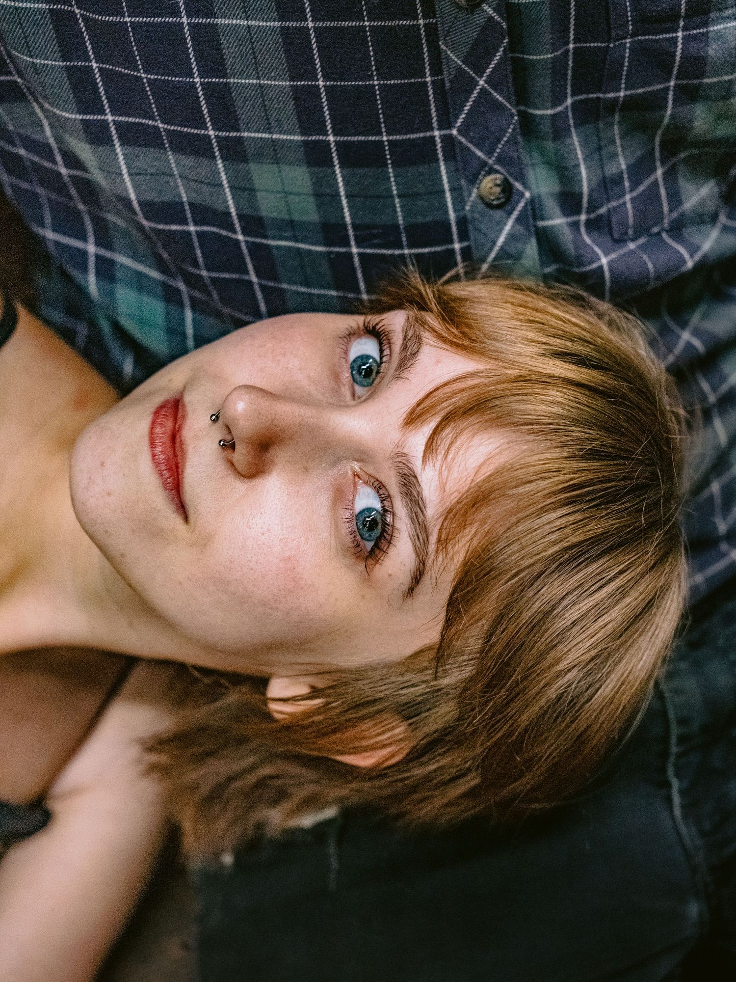 Close-up portrait against plaid fabric background.