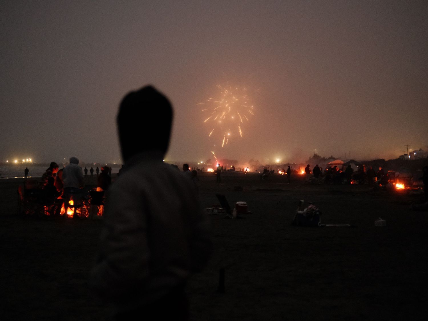 Fireworks display lighting up the night sky over a dark cityscape.
