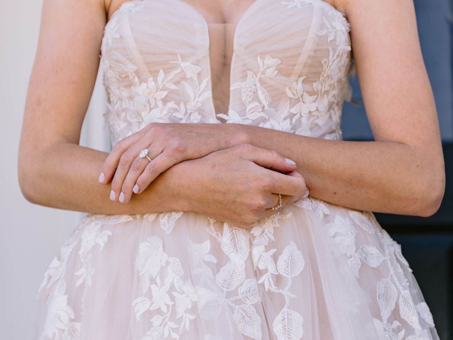 Close-up details of a delicate white lace wedding dress bodice with floral appliques.