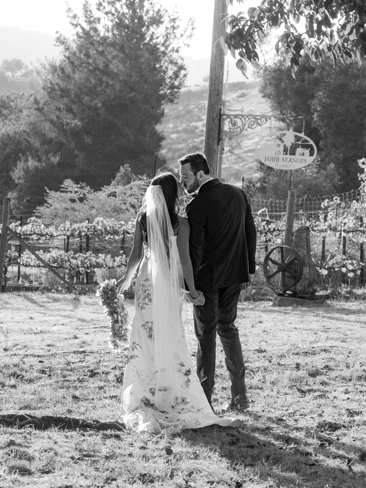 Black and white wedding portraits taken in a rustic outdoor setting with desert landscape.
