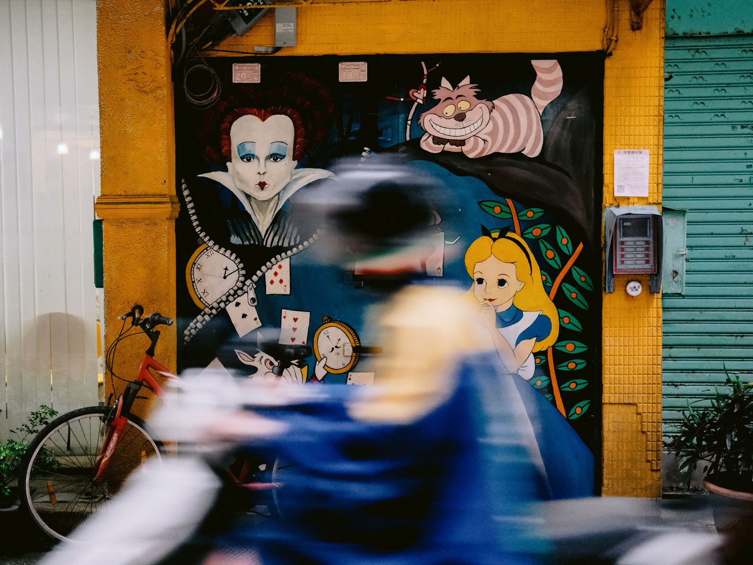 Colorful street art mural with cartoon characters on yellow and blue wall.