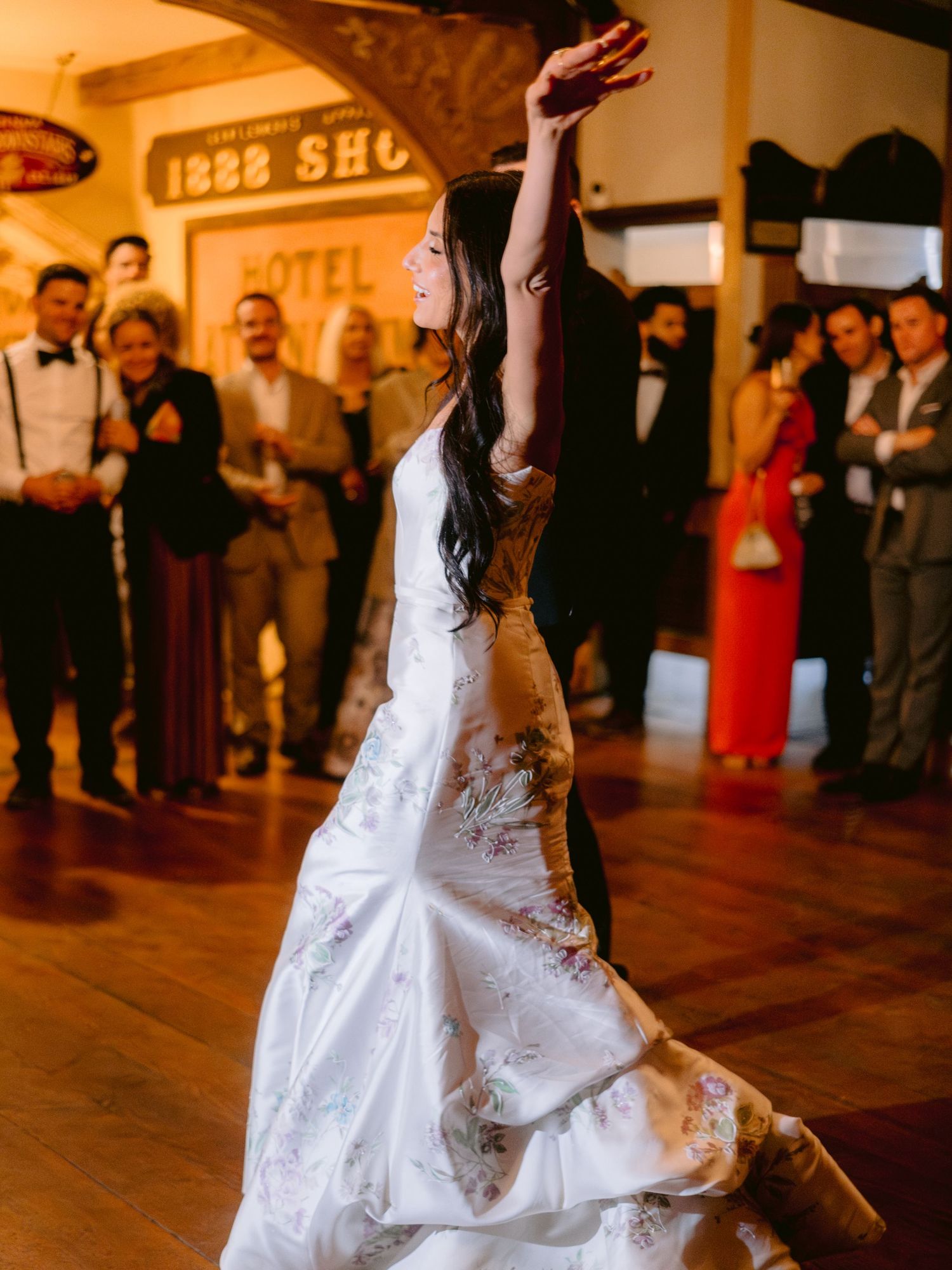 A wedding reception dance scene with guests watching in a vintage-themed venue.