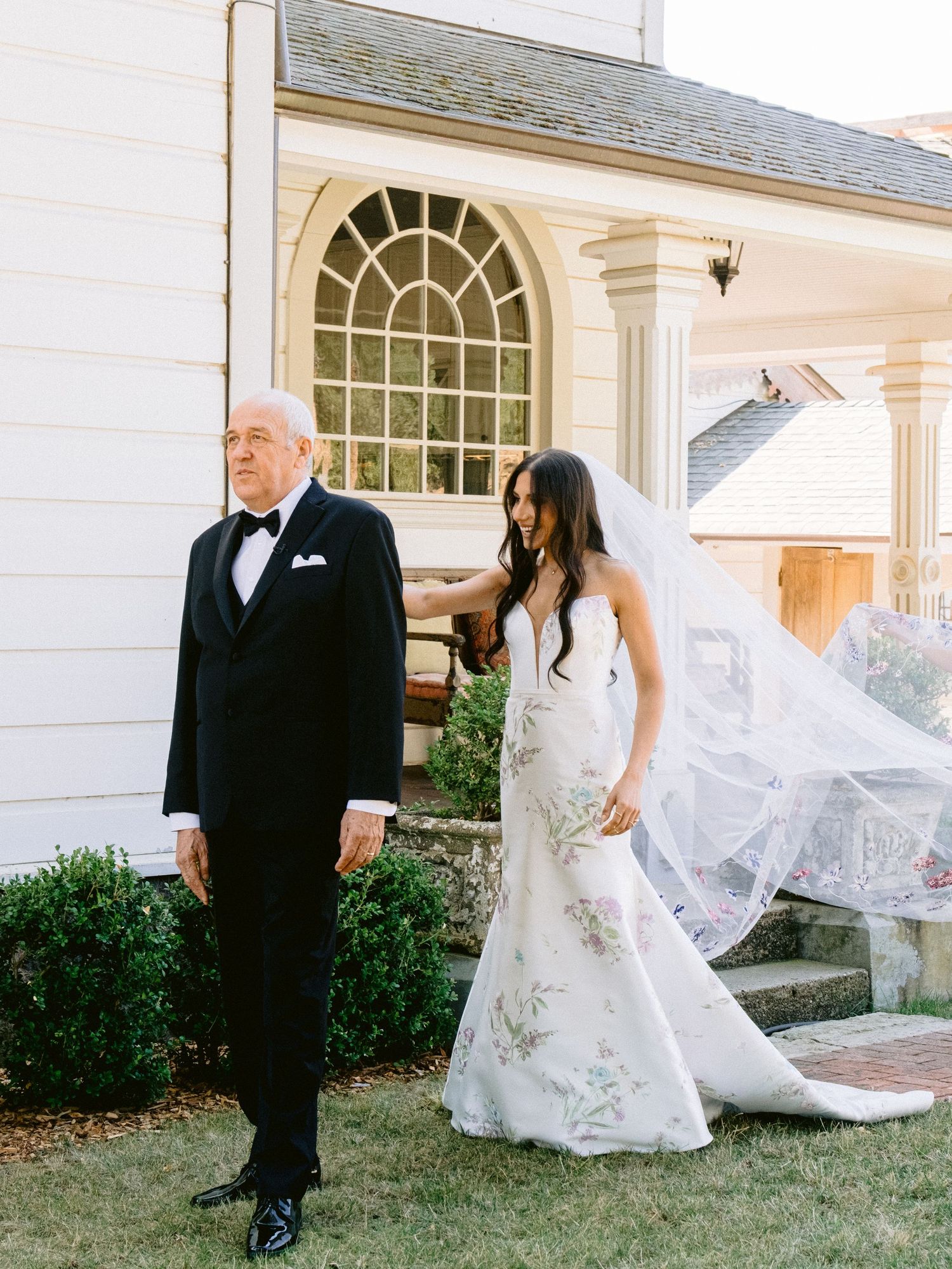 A series of wedding portraits taken outside a classic white building with arched windows.