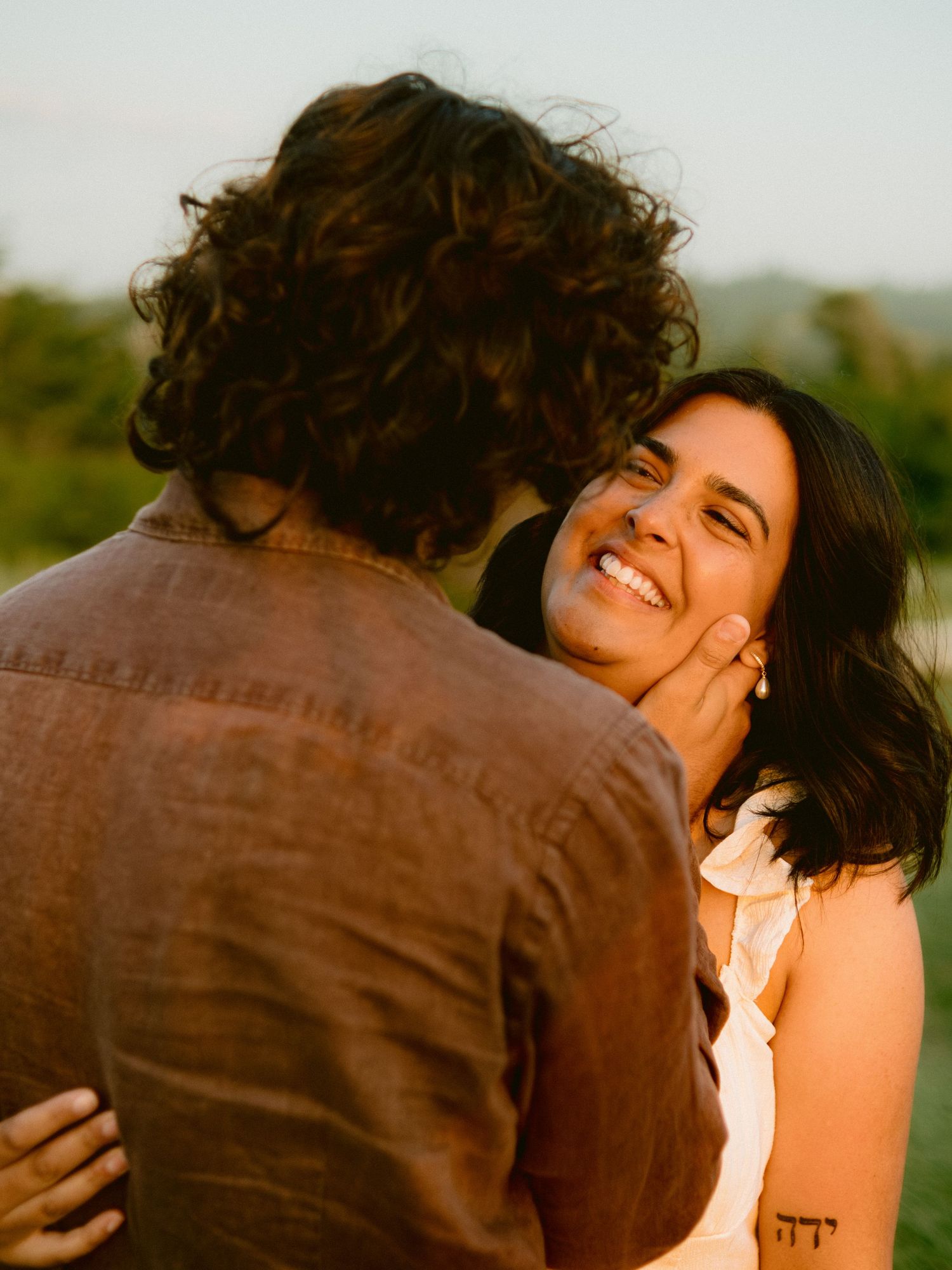 A romantic sunset photoshoot showing affectionate moments and laughter.
