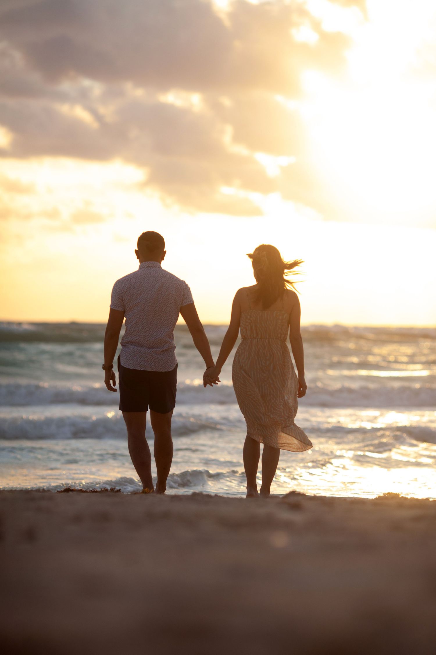 Epic sunrise couple shot—wind, nature, and the magnificent force of their love against breathtaking beauty.