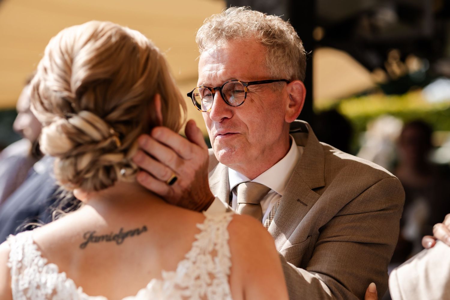 An emotional moment during a wedding celebration captured in warm indoor lighting.