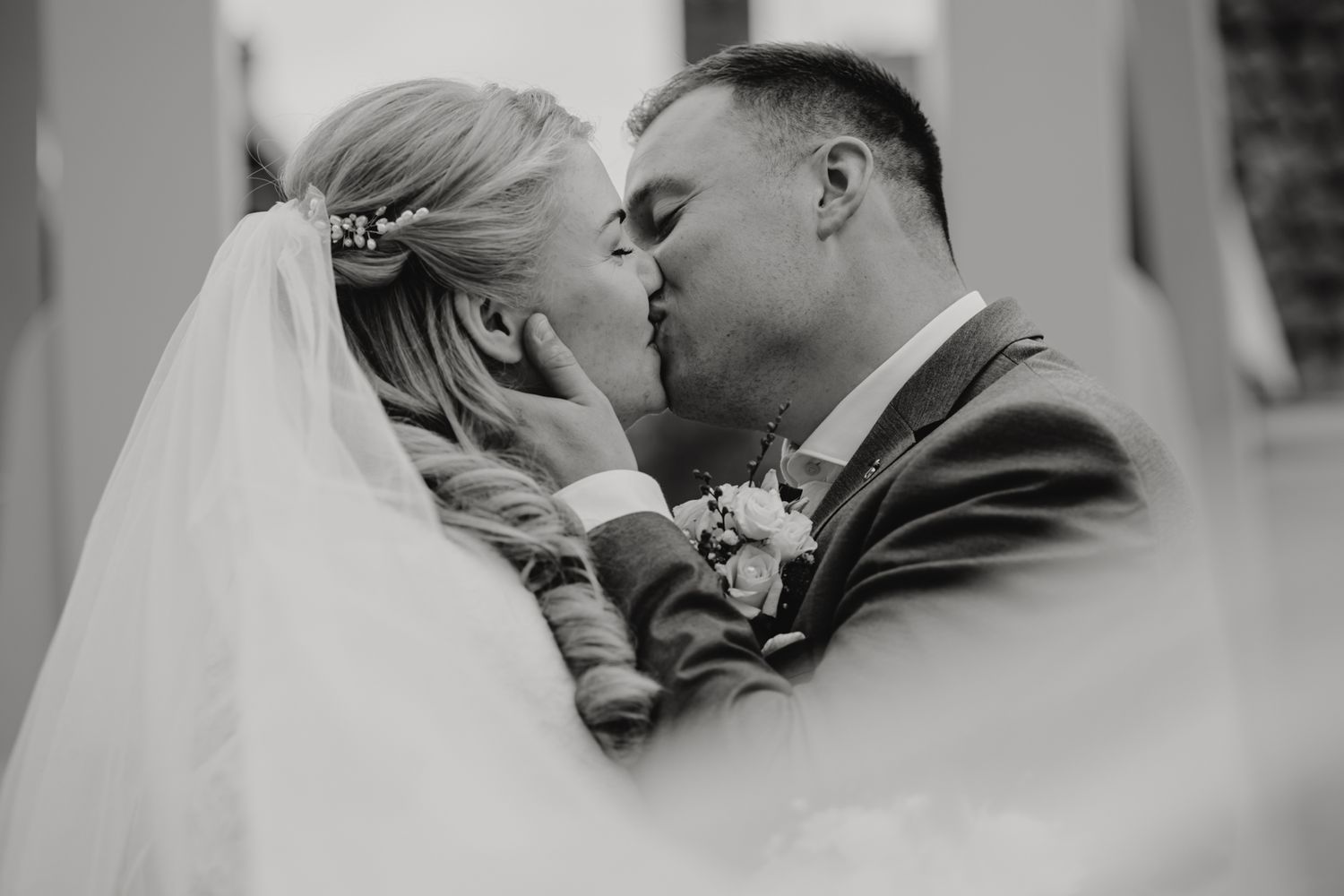 A romantic black and white wedding moment captured through delicate veil details.